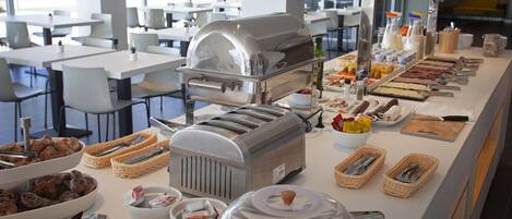A buffet setup with various food items and serving utensils.