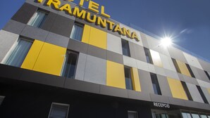 Un hotel llamado "HOTEL TRAMUNTANA" con un diseño moderno que presenta un patrón de cuadros en tonos amarillo y gris.