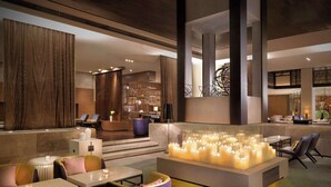 A modern lobby with seating areas, a central light feature, and a staircase leading to upper levels. - Hyatt Regency Tianjin East (Tianjin)