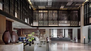 A spacious lobby with a high ceiling, modern furnishings, and decorative vases. - Hyatt Regency Tianjin East (Tianjin)