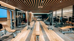 Ett gym med träningsbänkar, styrketräningsmaskiner och löpband.