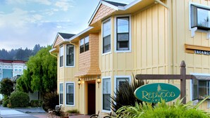 A two-story building with a sign reading "Redwood Suites." - Redwood Suites (Ferndale)