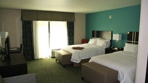 A hotel room with two beds, a desk, a chair, and a window with curtains. - Hampton Inn Carrizo Springs (Carrizo Springs)