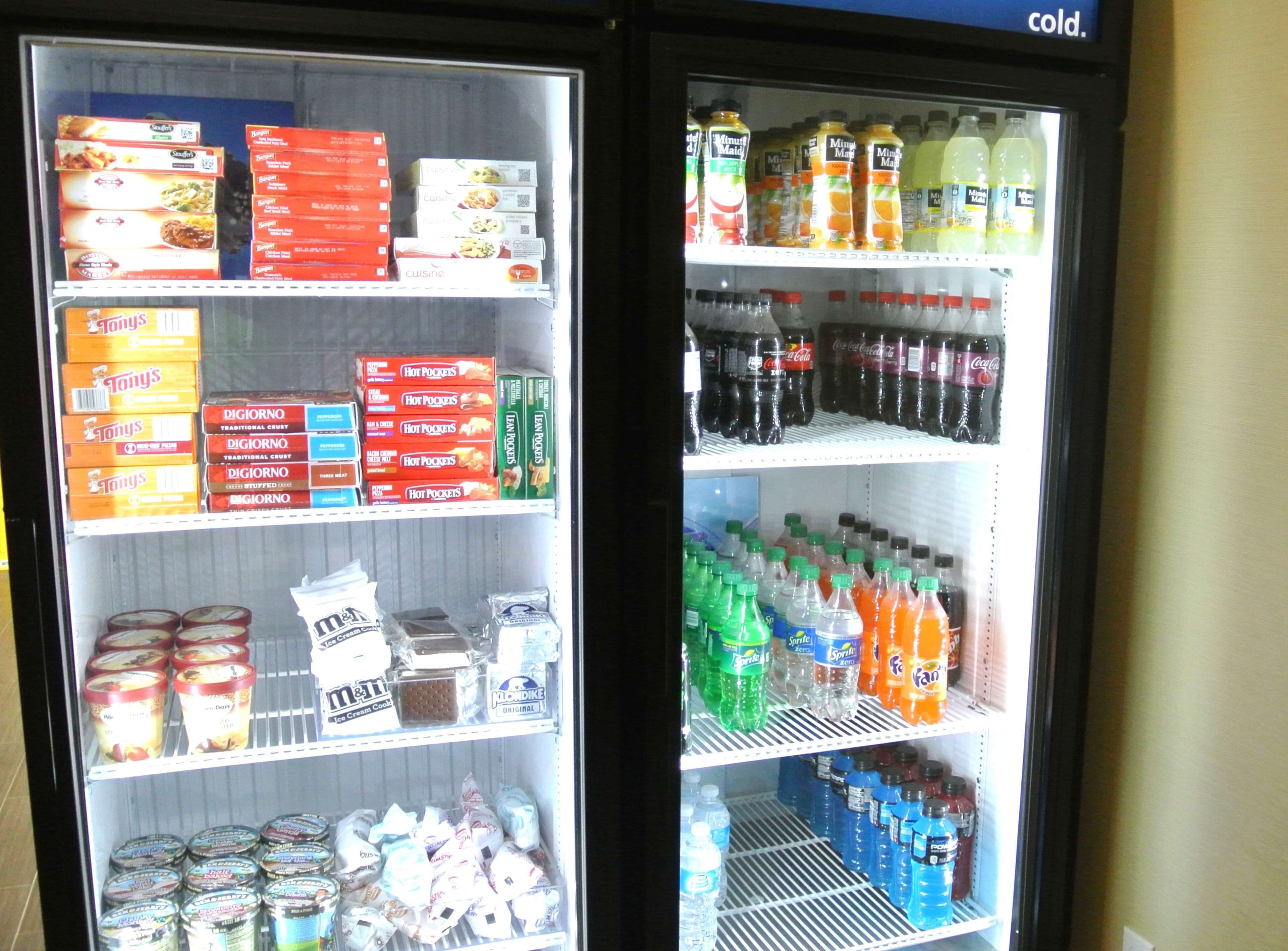 Vitrine refrigerada com diversos alimentos e bebidas.