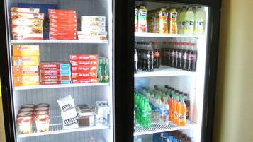 Vitrine refrigerada com diversos alimentos e bebidas.