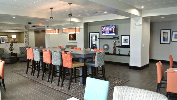 A hotel lobby with a large bar area, seating, and a television screen. - Hampton Inn Carrizo Springs (Carrizo Springs)