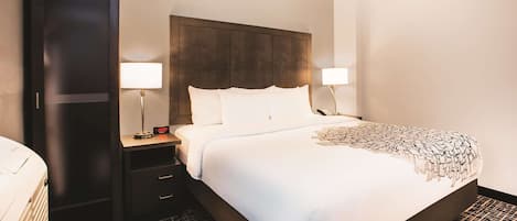 Habitación de hotel con una cama grande, dos mesitas de noche, un armario y un piso con diseño.