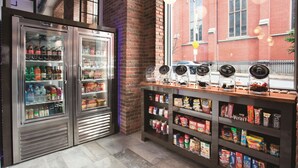 A snack bar with refrigerated drinks and shelves stocked with snacks. - La Quinta Inn & Suites by Wyndham Baltimore Downtown (Baltimore)