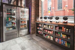 Un bar de aperitivos con bebidas refrigeradas y estantes llenos de bocadillos.