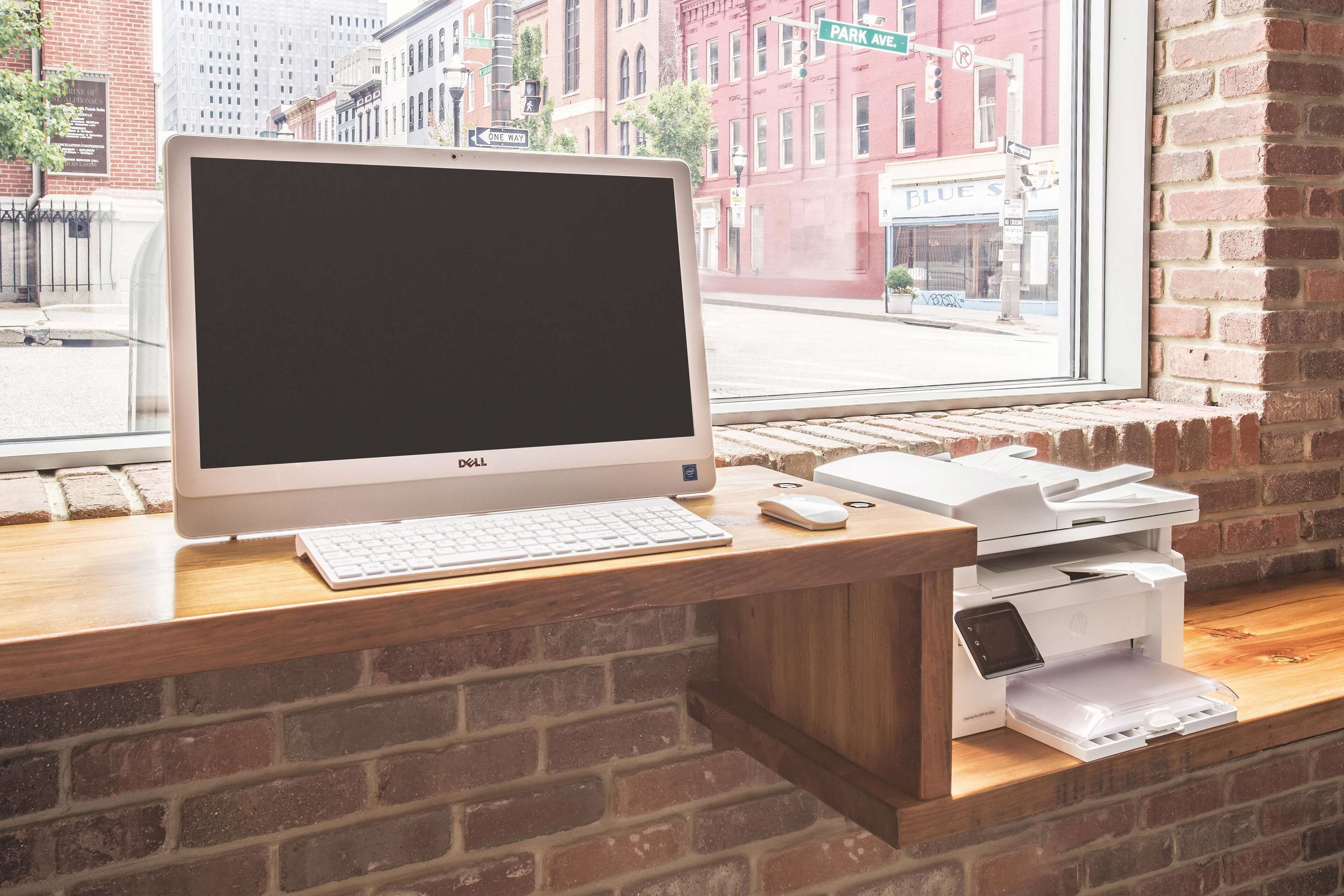 A Dell desktop computer on a wooden desk with a printer and keyboard.