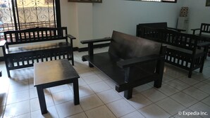 A room with a tiled floor, wooden benches, a table, and a painting on the wall. - Boracay Travelodge Beach Resort (Boracay Island)