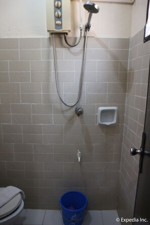 A small bathroom with a shower, toilet, and a blue bucket. - Boracay Travelodge Beach Resort (Boracay Island)