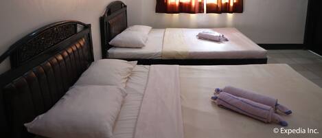 A room with two single beds, a headboard, a window with curtains, an air conditioning unit, and a tiled floor.