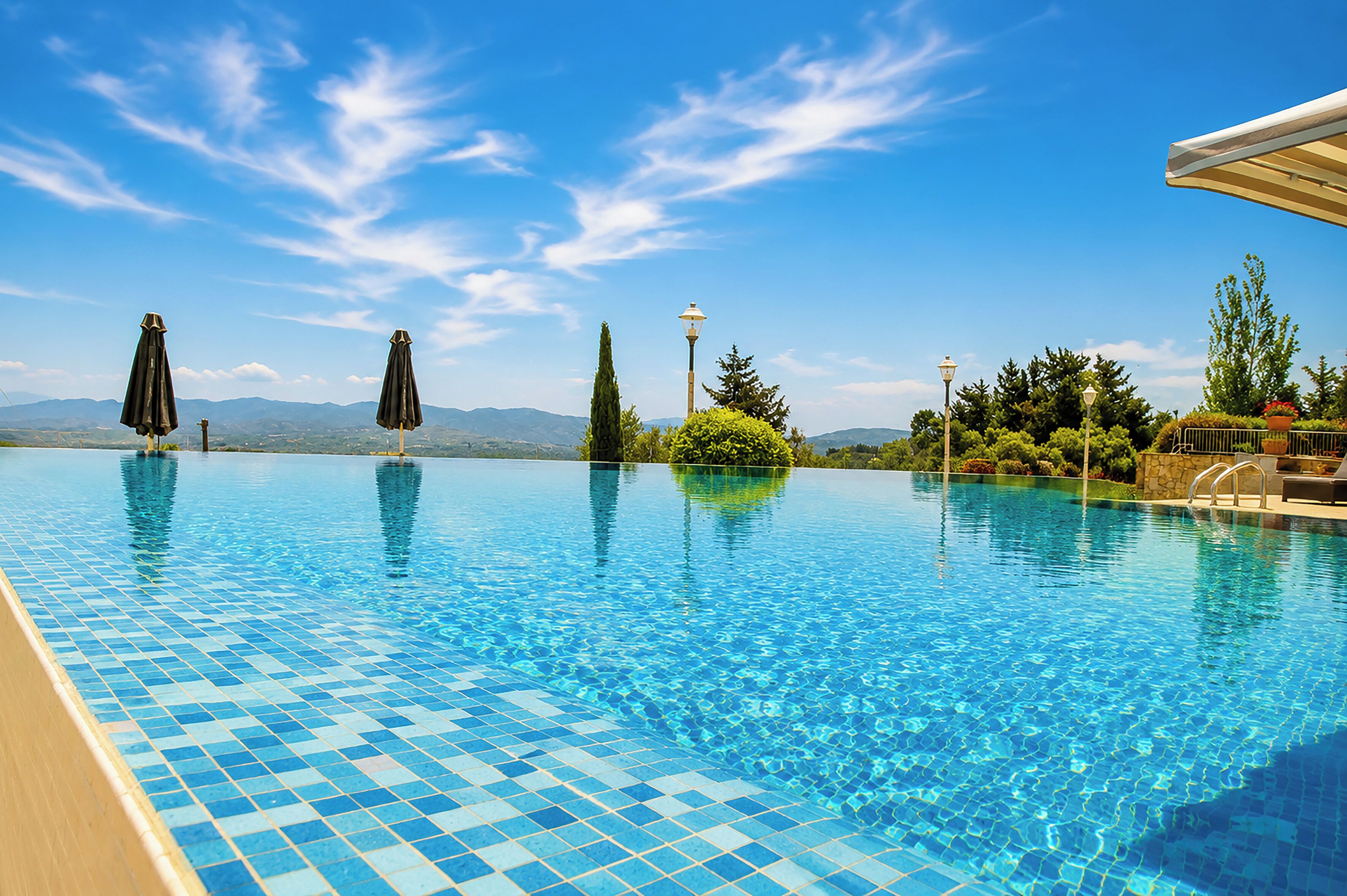 Seasonal outdoor pool, an infinity pool, pool umbrellas, pool loungers