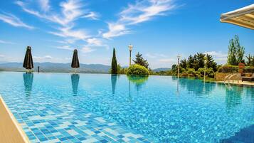 Seasonal outdoor pool, an infinity pool, pool umbrellas, pool loungers