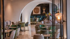 A modern dining area with round tables, green chairs, and a central seating area with sofas. - Droushia Heights (Droushia)