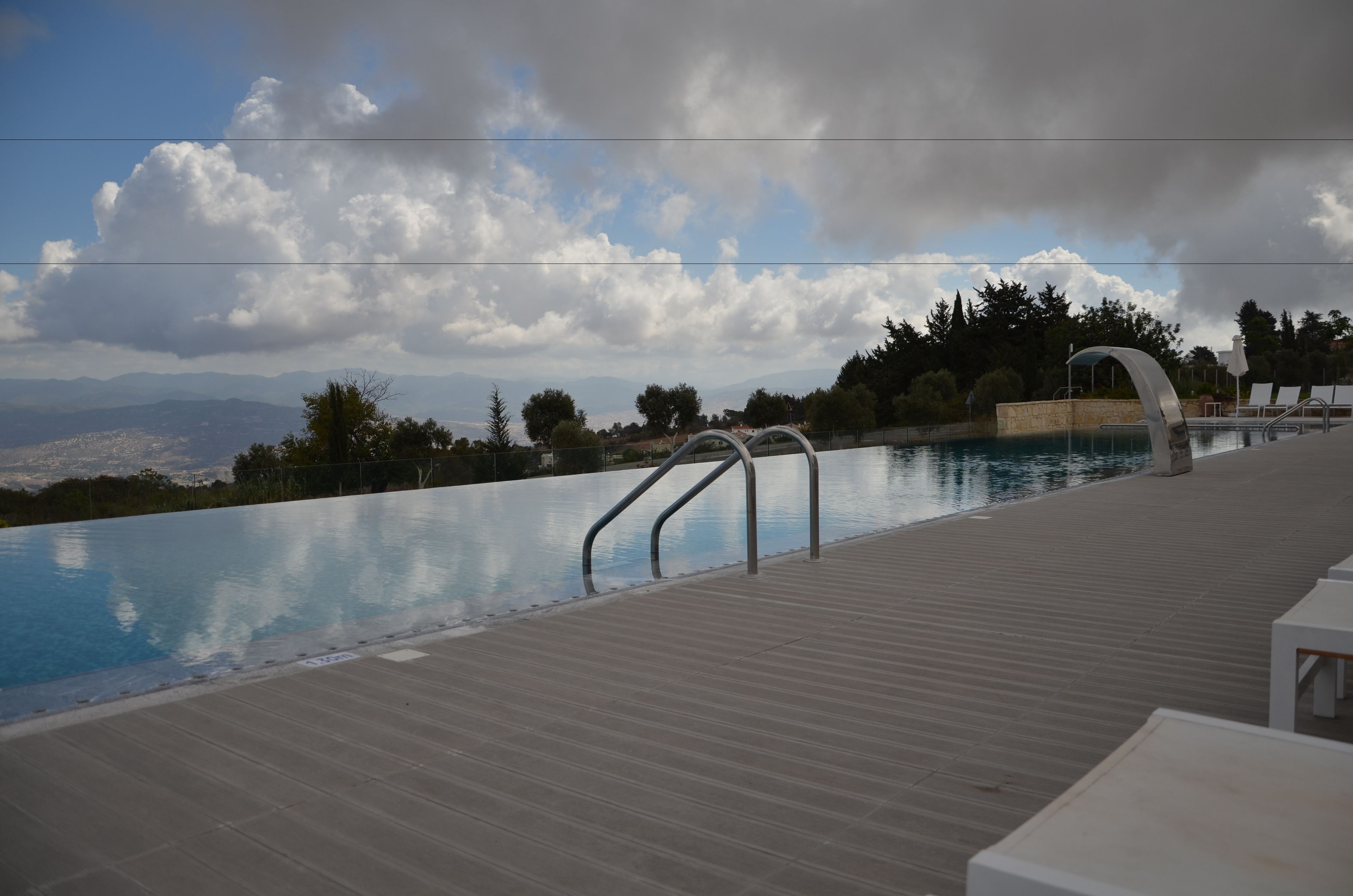 Una piscina al aire libre de temporada, una piscina infinita, sombrillas
