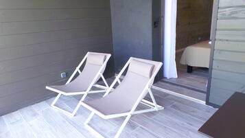 Two lounge chairs with a view of a wooden interior and a tiled floor.
