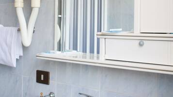 Ein Badezimmer mit Waschbecken, Spiegel und Handtuchhalter.