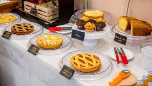 Une vitrine de boulangerie présentant divers produits de boulangerie, comme des tartes, des muffins et un pain.
