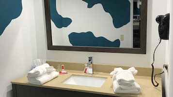 A hotel bathroom with a sink, mirror, and towels.