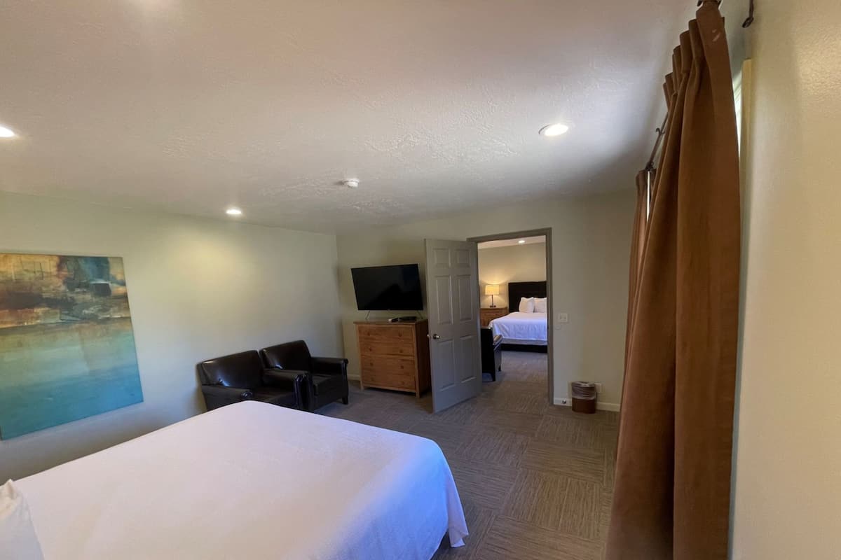 A hotel room with a bed, a television, a desk, and a chair.