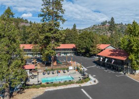 Un hotel con piscina, mobiliario exterior y aparcamiento.