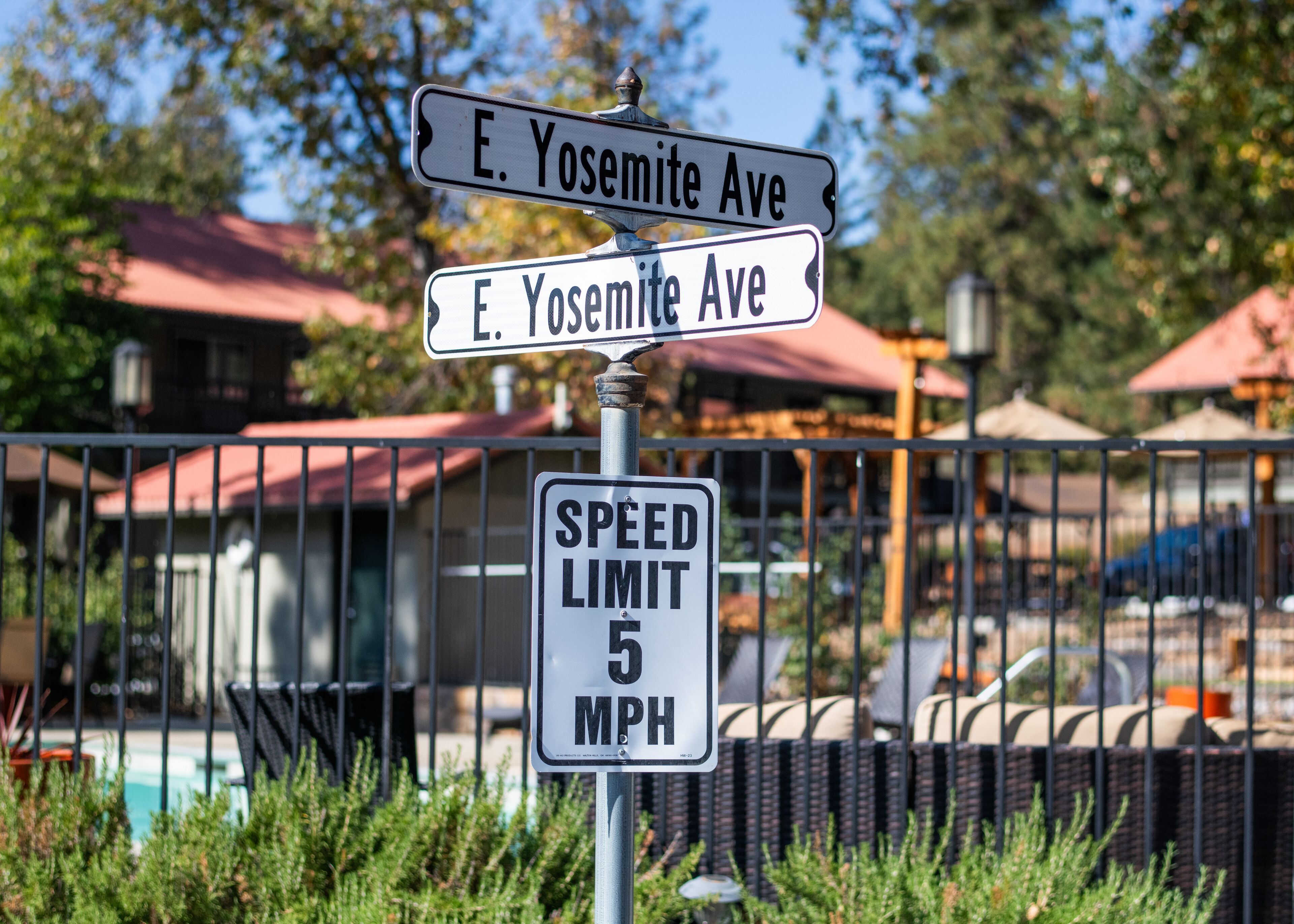 Señal de calle para la Avenida E. Yosemite y un cartel de límite de velocidad de 8 kilómetros por hora.