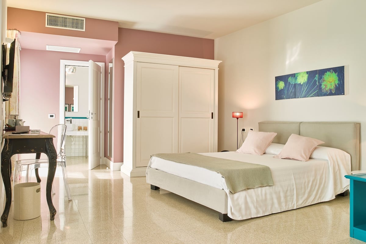 Een slaapkamer met een bed, nachtkastje en een kledingkast.