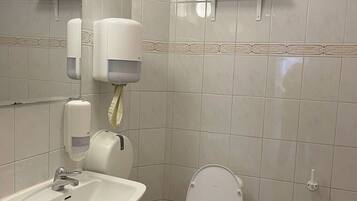 Baño con lavamanos, inodoro y secamanos.