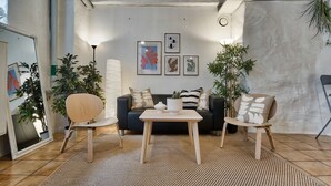 A modern living room with a sofa, two chairs, a coffee table, and framed artwork on the wall. - Nomad Cave (Stockholm)