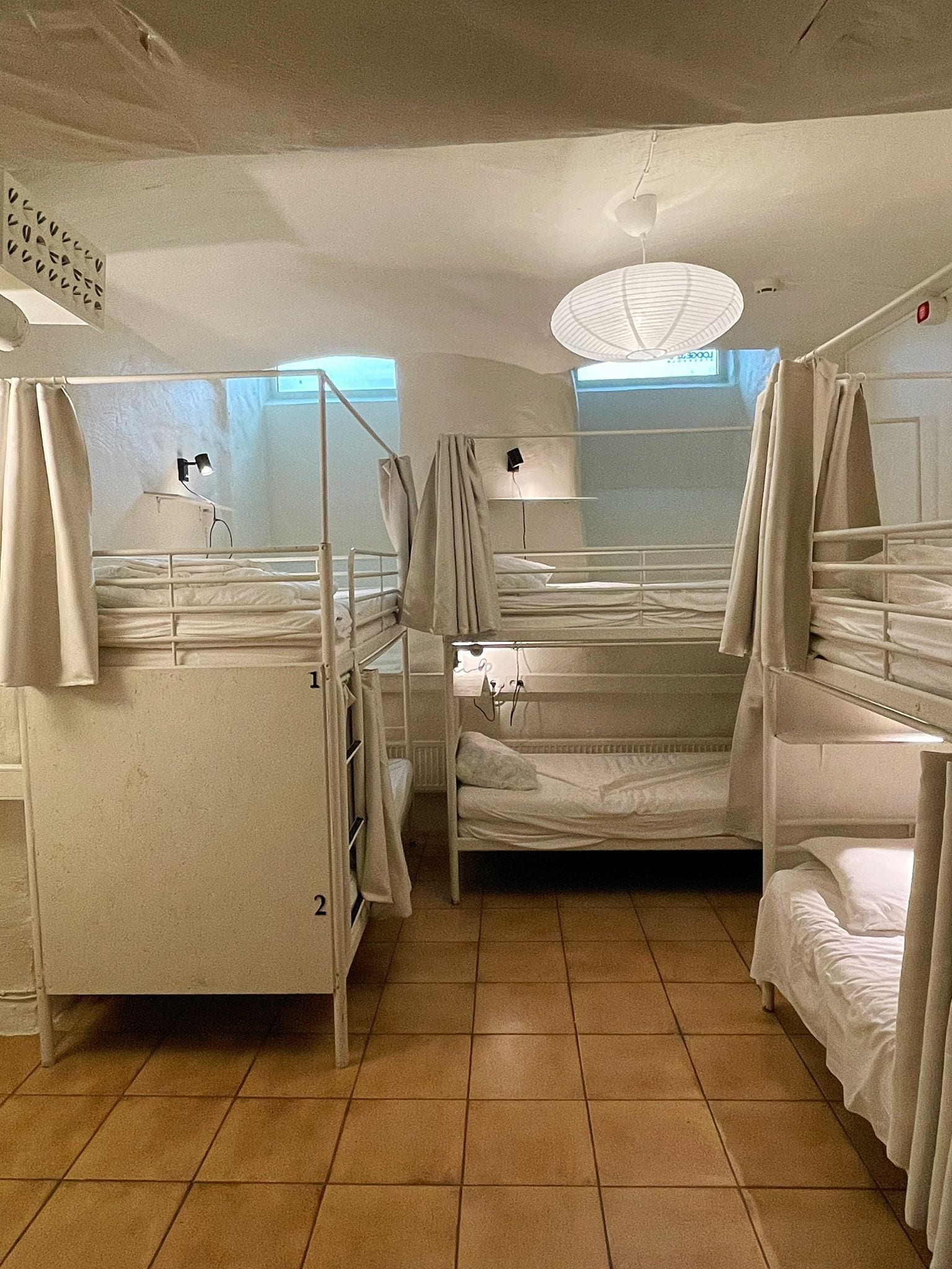 Un dormitorio con literas, una ventana y una lámpara en el techo.