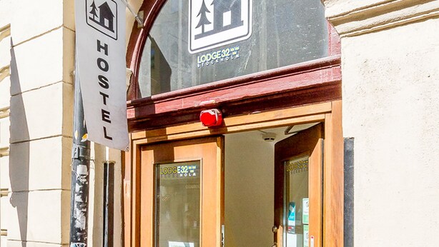 A hotel entrance with a sign indicating it is a hostel. - Nomad Cave (Stockholm)