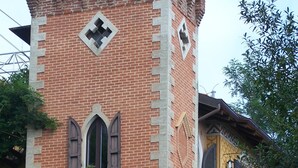 Una torre de ladrillo con una ventana y un balcón.