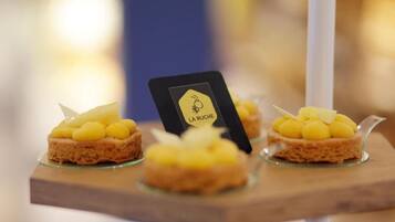 Une présentation de desserts avec une carte en bois portant l’inscription « LA RUCHE ».