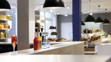 Un espace bar avec un comptoir, des bouteilles, des verres et un verre à vin.