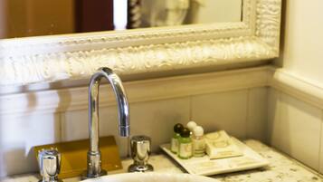 A bathroom with a white sink, a mirror, and a towel rack.