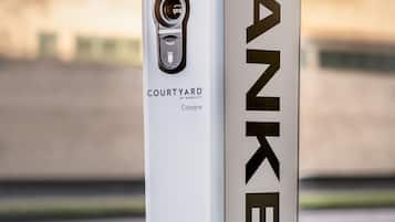 En TANKE elbil-ladestation med display og ladeport, mærket "COURTYARD" af MARSHT.