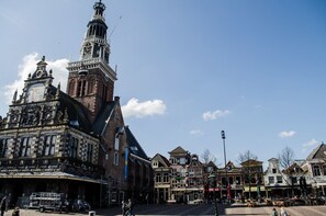 A historic building with a clock tower, a covered market area, and traditional architecture. - King's Inn City Hostel - Hotel Alkmaar - Hostel (Alkmaar)