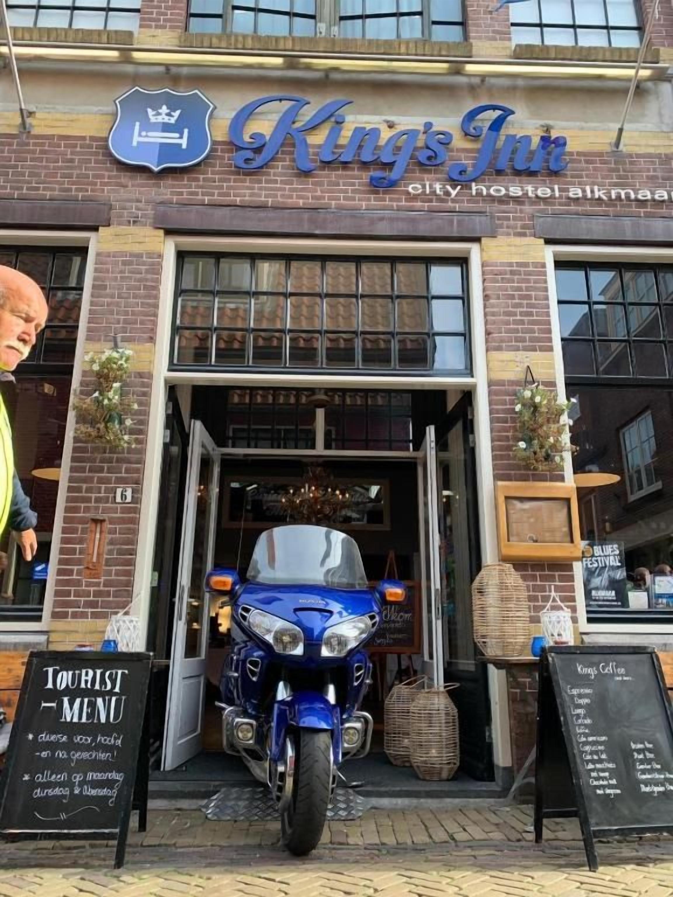 A building with a sign reading 'King's Inn' and a motorcycle parked in front.