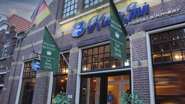 A hotel with a sign reading "King's Inn" and flags.