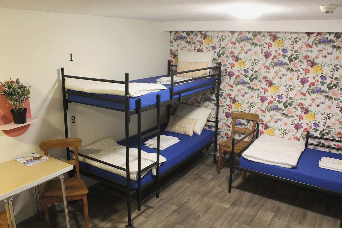 Un dormitorio con literas, un escritorio y una silla.