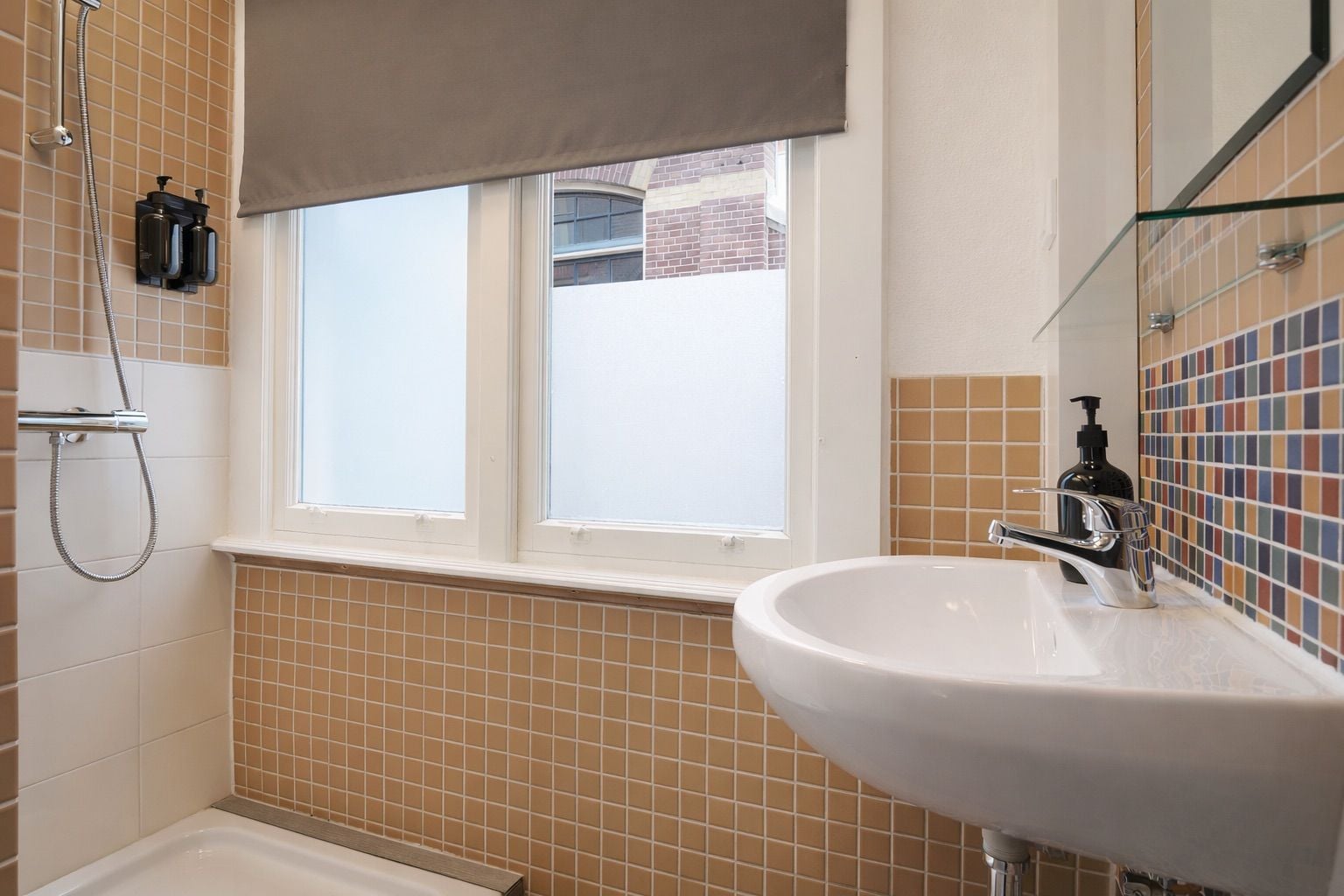 Une salle de bain avec une baignoire, une fenêtre et un lavabo avec un miroir au-dessus.