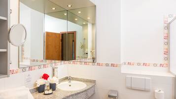 A bathroom with a granite countertop sink, a large mirror, and a towel rack.