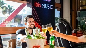 A person toasting with a glass of champagne at a table with a Stella Artois bucket. - ibis Foz do Iguaçu (Foz do Iguaçu)