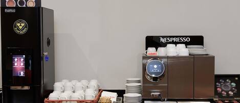 A coffee station with a FreshMore machine and a Nespresso machine, both equipped with multiple coffee cups and plates.