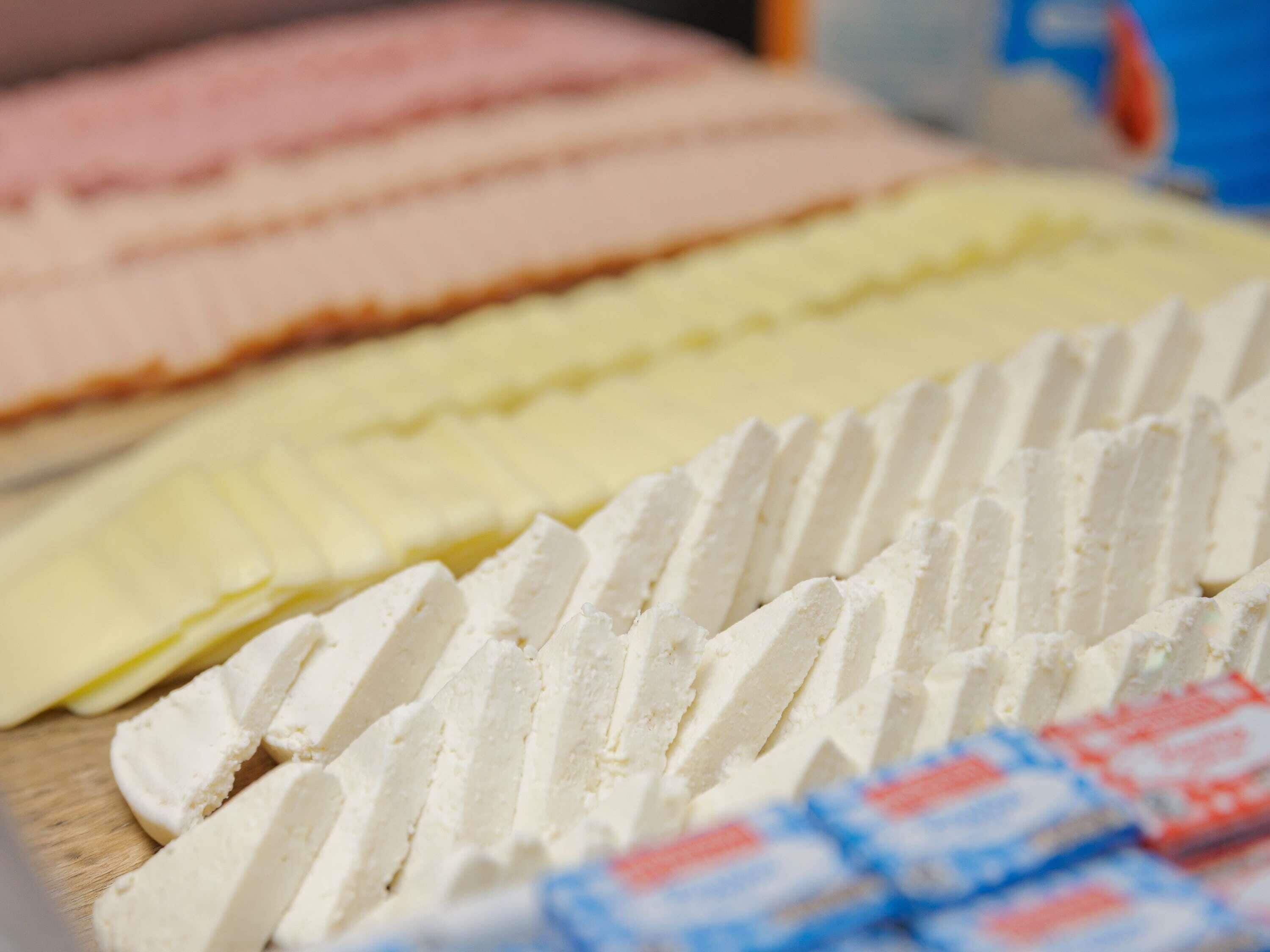 A variety of cheeses on a wooden board.
