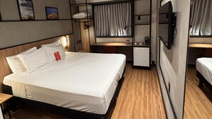 A modern hotel room with a large bed, a desk, a small kitchenette, and a TV. - ibis Foz do Iguaçu (Foz do Iguaçu)