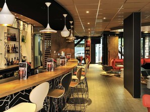 A bar area with stools, a counter, and a menu stand. - Ibis Rotterdam City Centre (Rotterdam)
