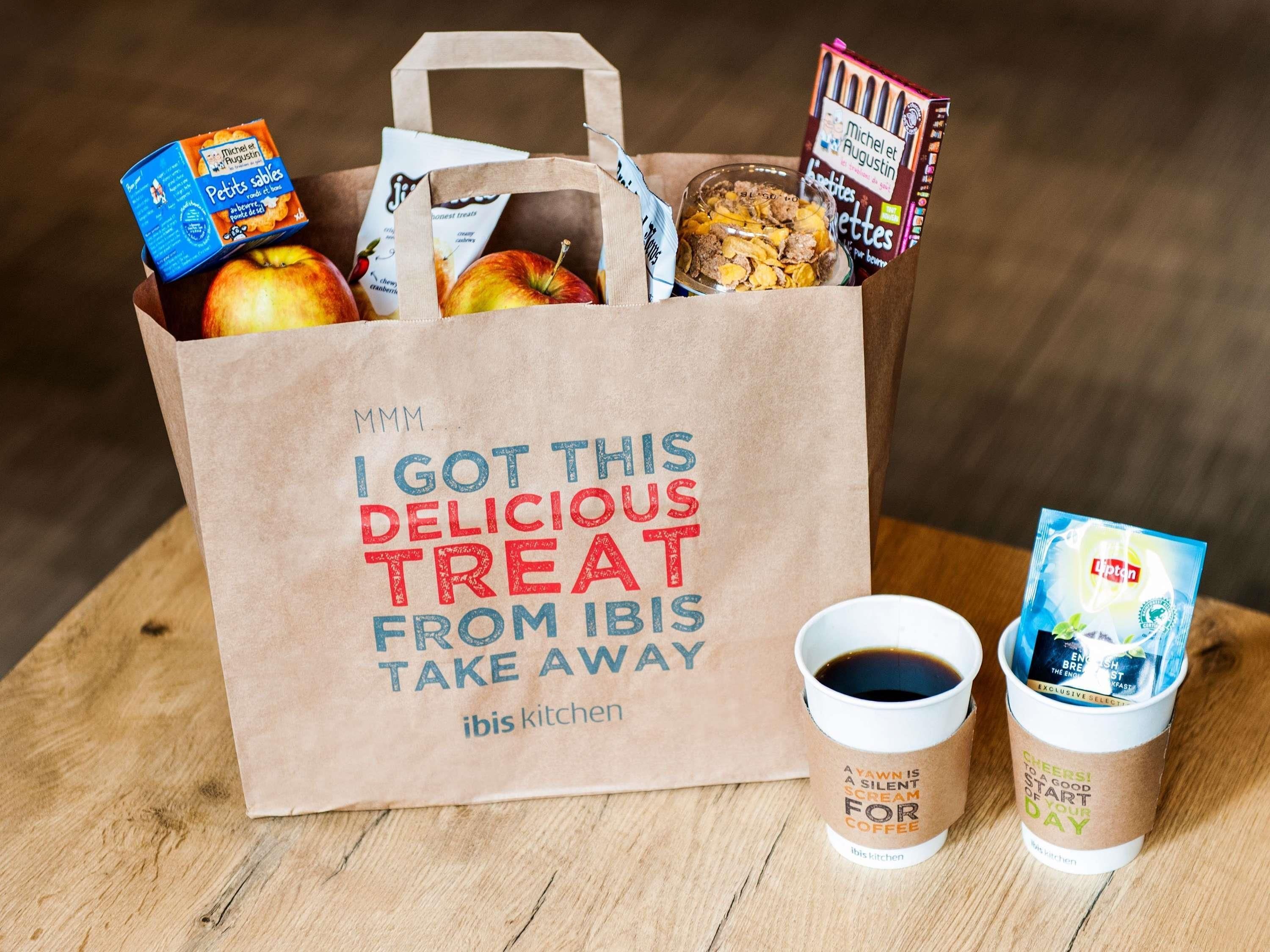 Una bolsa de papel con un mensaje, una taza de café y una bolsita de té.